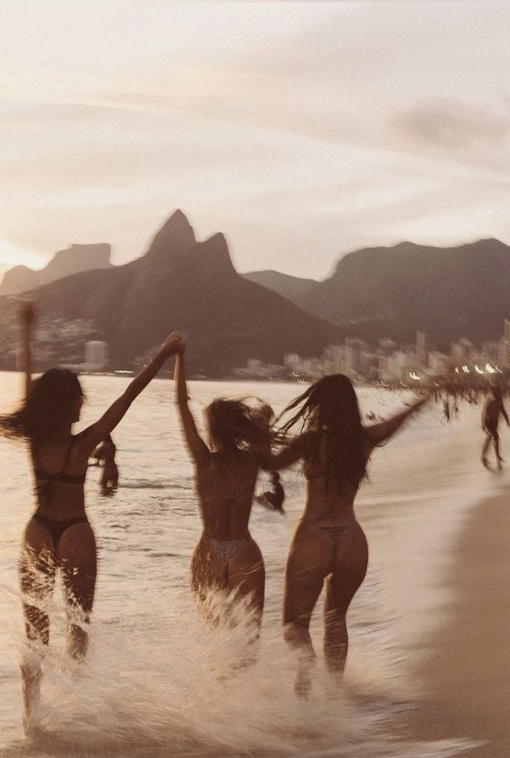 Women running along the beach in Cabo wearing custom bikinis they designed with Bikini Bay’s build-your-own bikini kits. Friends laughing and enjoying a tropical vacation in colorful personalized swimwear with unique charms and beach-inspired styles.